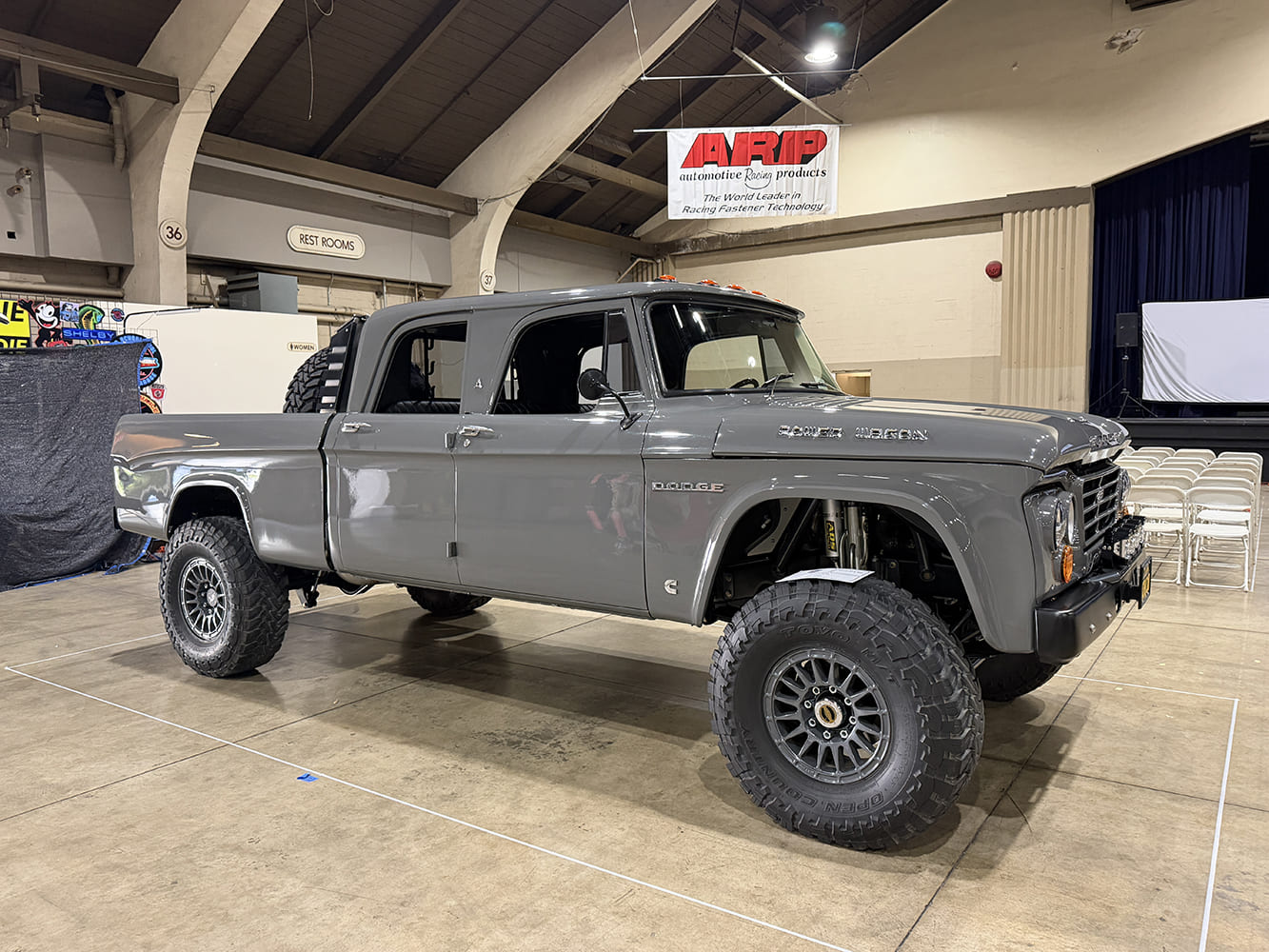 Front three-quarter perspective of a glossy battleship gray four-door Dodge Power Wagon 4x4 pickup on massive Toyo Open Country off-road tires.
