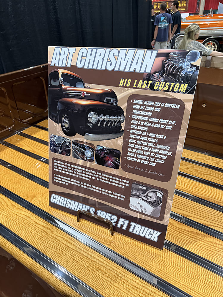 Close-up of the wooden display stand and informational poster detailing the specs and history of drag racing legend Art Chrisman's personal 1952 Ford F-1 custom truck.