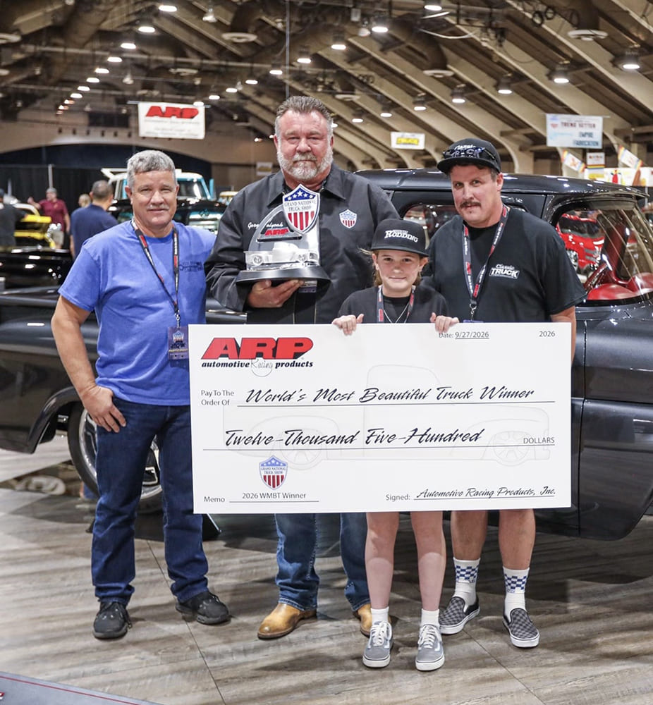 The winning build team and family proudly holding the ARP $12,500 oversized check and custom trophy in front of Gary Holyoak’s 1963 Chevrolet C10 on the show floor.