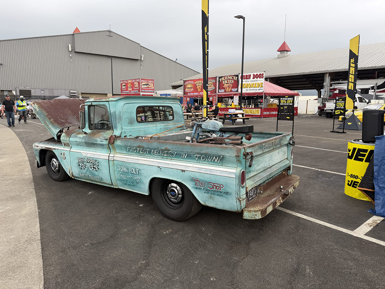 Rear three-quarter perspective of a lowered light blue vintage Chevrolet C10 service truck with vintage shop lettering and custom steel wheels.