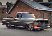 Low front three-quarter angle of a custom metallic gray 1972 Ford F-100 pickup showing large Wilwood disc brakes behind brushed wheels.