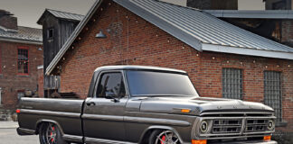 Low front three-quarter angle of a custom metallic gray 1972 Ford F-100 pickup showing large Wilwood disc brakes behind brushed wheels.