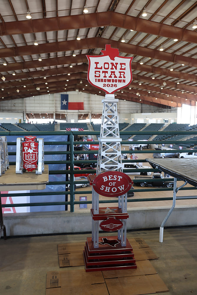 Custom oil derrick-style metal trophy labeled Best of Show for Lone Star Throwdown on display inside an arena concourse.