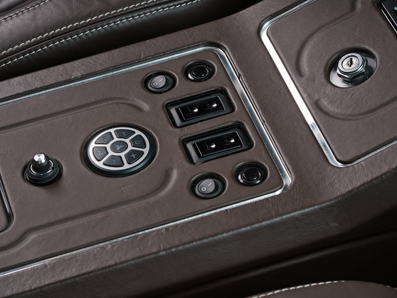Top-down view of the custom center console controls including a JL Audio circular control dial, power window switches, and accent buttons.