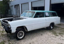 1966 Nova Gasser Build Front three-quarter view of a white 1966 Chevy II Nova wagon gasser featuring a turquoise roof, straight front axle, tall velocity stacks, and American Racing wheels parked outside a workshop.
