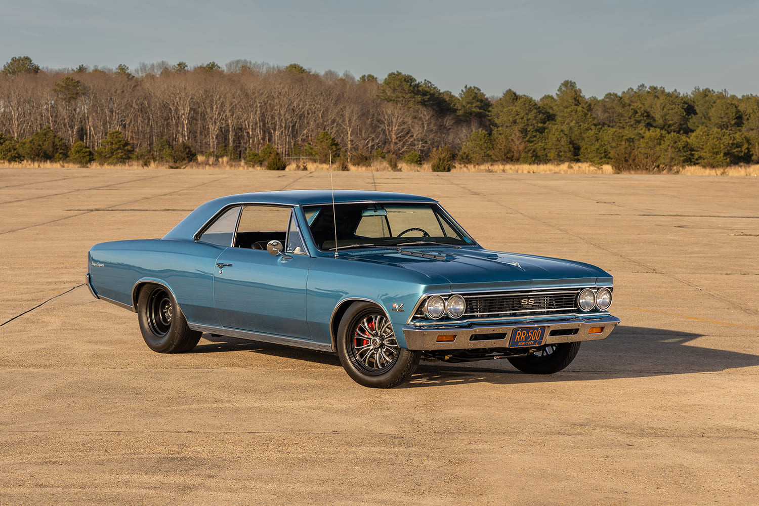 Front three-quarter view of a Marina Blue 1966 Chevrolet Chevelle SS featuring black rear steel wheels, polished front drag wheels, and New York license plate "RR-500".