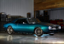 Front three-quarter view of a teal metallic pro-touring 1967 Chevrolet Camaro parked on a polished shop floor.