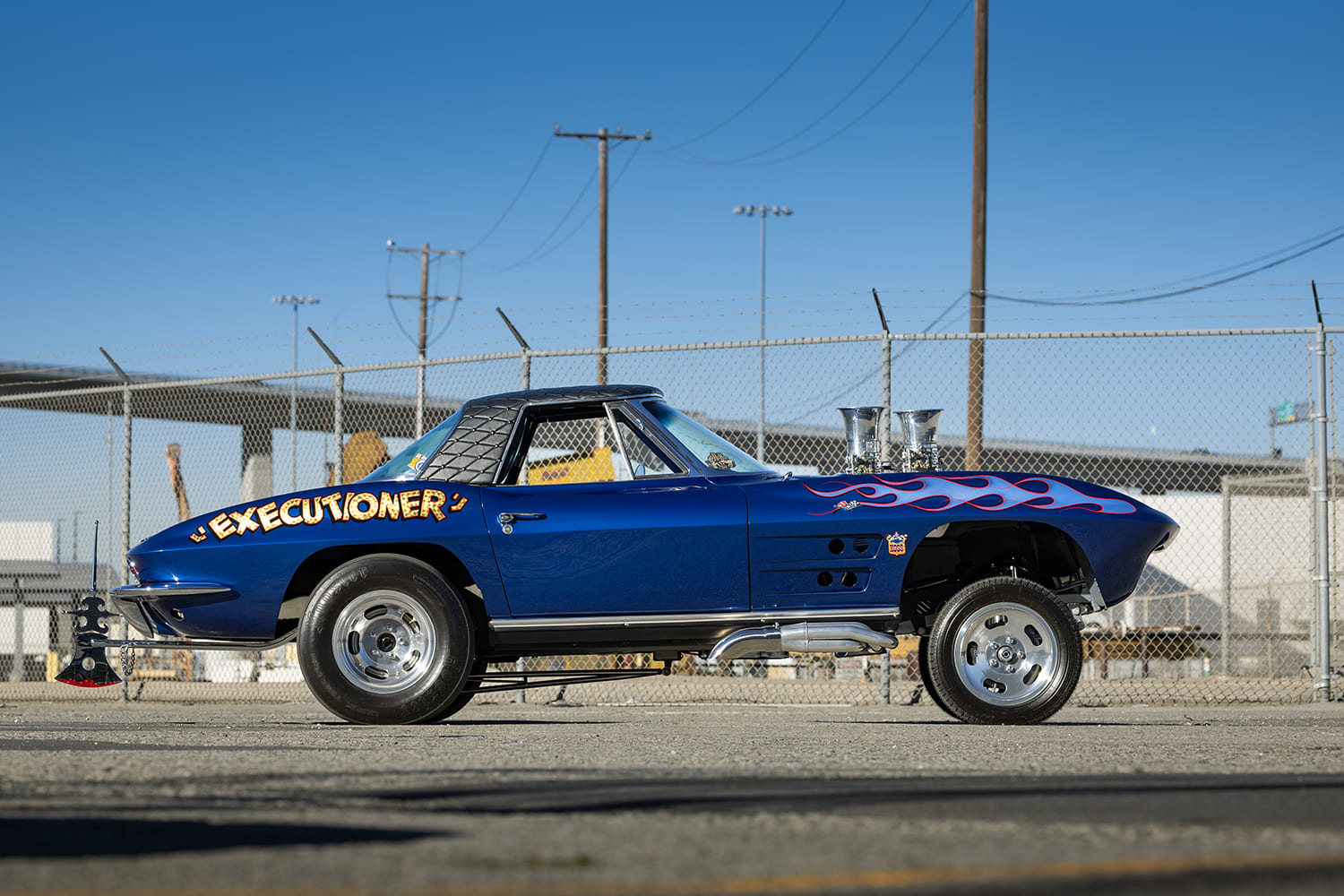 Side profile of a 1964 Chevy Corvette gasser showing the nose-high stance, Executioner graphic lettering, and side-exit exhaust.
