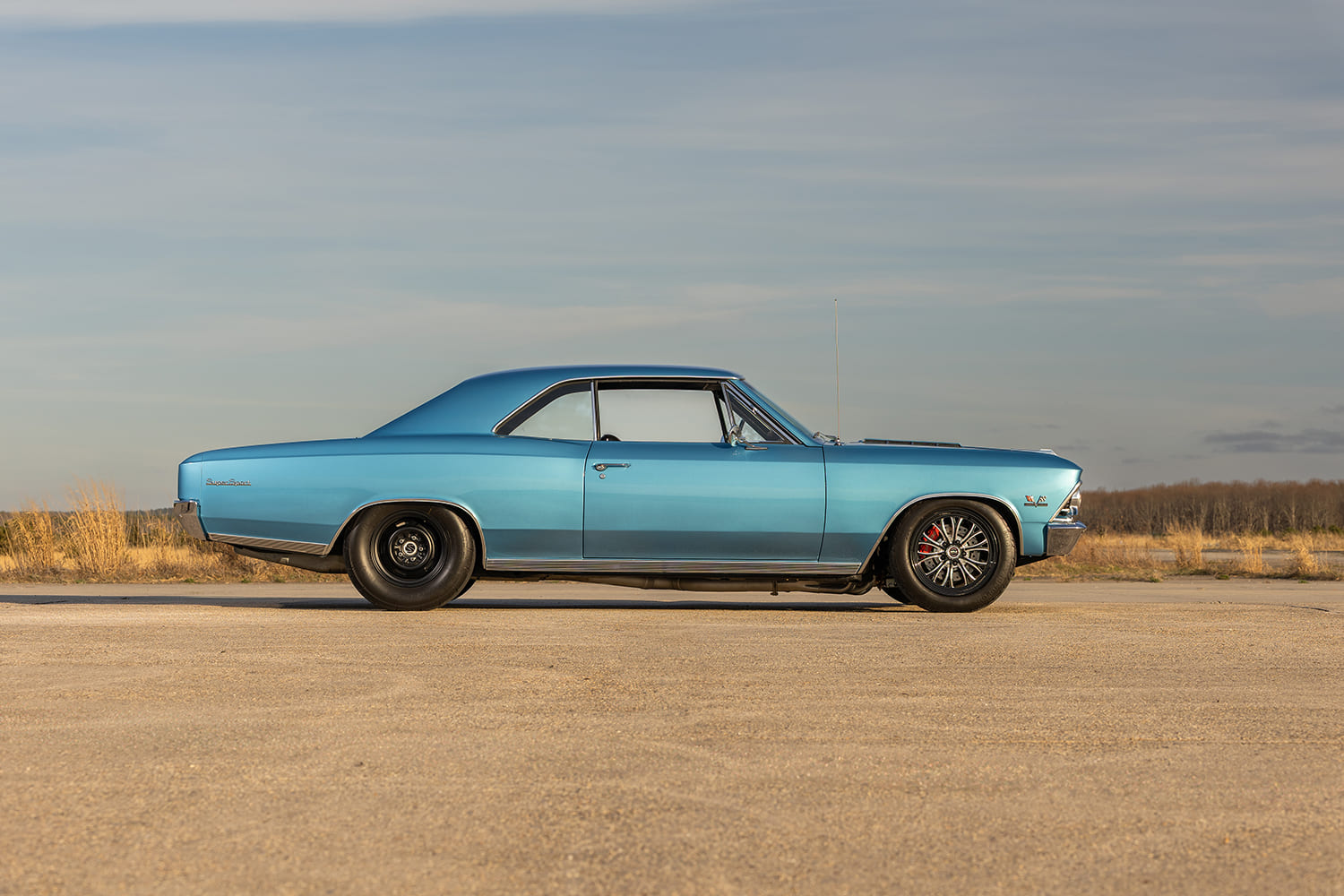 Full passenger-side profile of the 1966 Chevrolet Chevelle showing the classic muscle car rake with black rear steelies and multi-spoke front runner wheels.