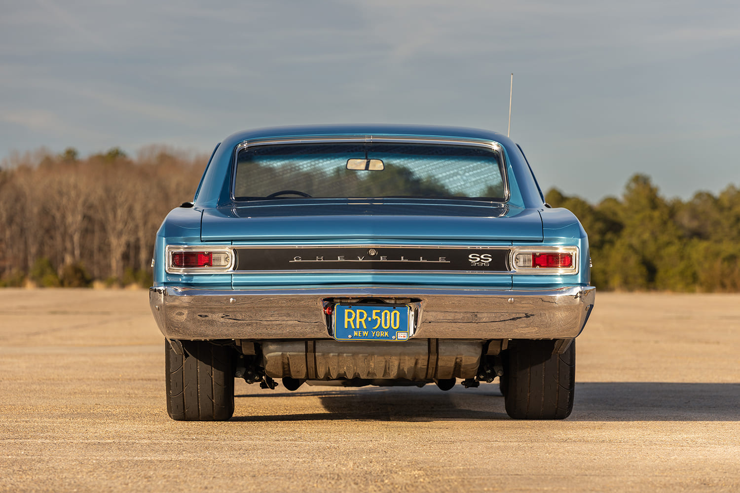 Direct rear perspective of the 1966 Chevelle SS showing the ribbed trunk blackout panel, SS 396 badge, fuel tank, and wide black drag radial tires.