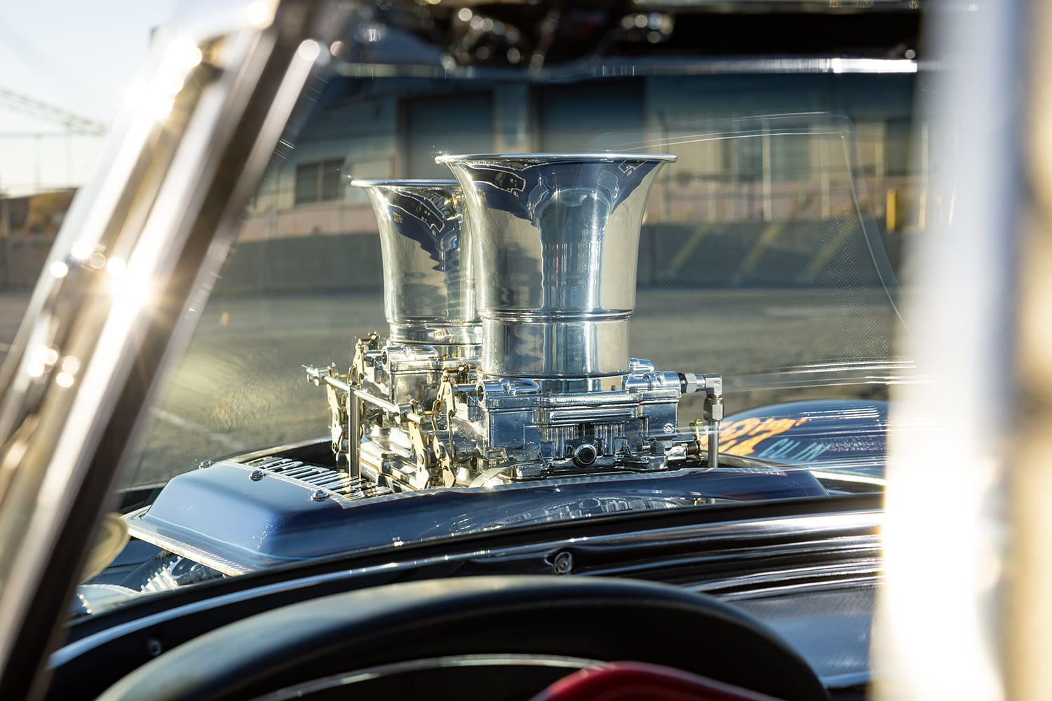 View looking out the windshield of a 1964 Corvette gasser past the dual polished carburetor velocity stacks.
