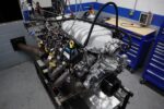 7.3 Godzilla Power: Holley Intake, BTR Cam & Ultimate Headers Front three-quarter angle of a Ford 7.3L Godzilla V8 test engine equipped with a cast aluminum Holley intake manifold and dyno exhaust headers on the test stand.