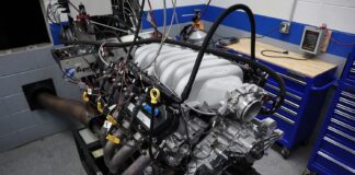 Front three-quarter angle of a Ford 7.3L Godzilla V8 test engine equipped with a cast aluminum Holley intake manifold and dyno exhaust headers on the test stand.