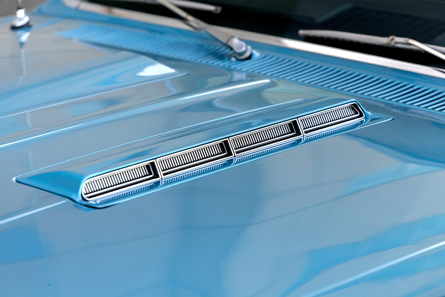 Macro view of the die-cast chrome simulated intake louver inserts on the raised center cowl of the 1966 Chevelle SS hood.