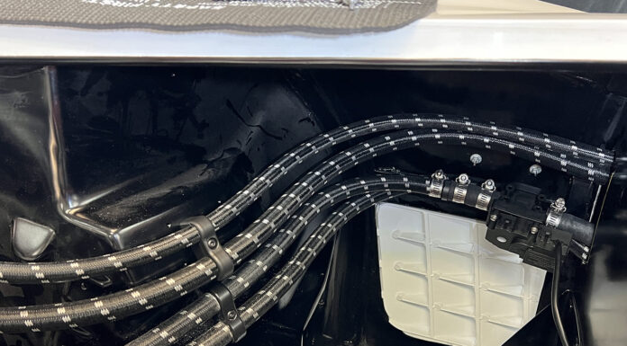 Plumbing Pointers: All About High-Tech Hoses Clean routing of four black braided Pure Stealth hoses secured with billet chassis clamps along the gloss black inner fender and firewall.