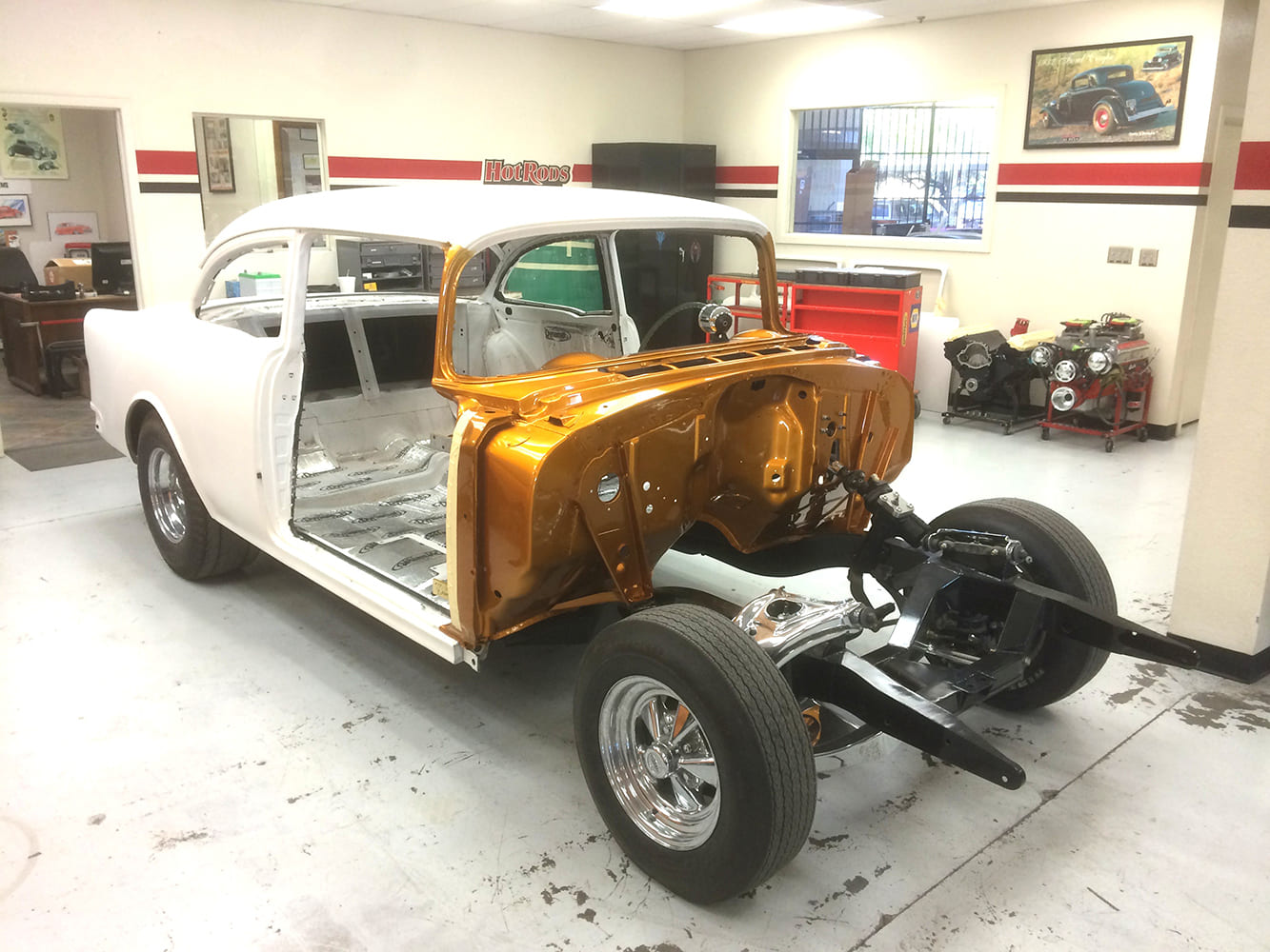 Reproduction body for the 55 Chevy Gasser project showing the custom PPG Pagan Gold firewall and independent front suspension roller chassis.