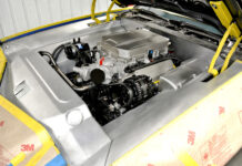 1981 Camaro Custom Engine Bay High three-quarter overview of the finished brushed aluminum engine bay panels framing the supercharged LS engine, with fenders masked in protective paper.