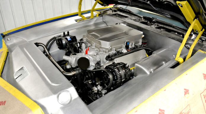 1981 Camaro Custom Engine Bay High three-quarter overview of the finished brushed aluminum engine bay panels framing the supercharged LS engine, with fenders masked in protective paper.