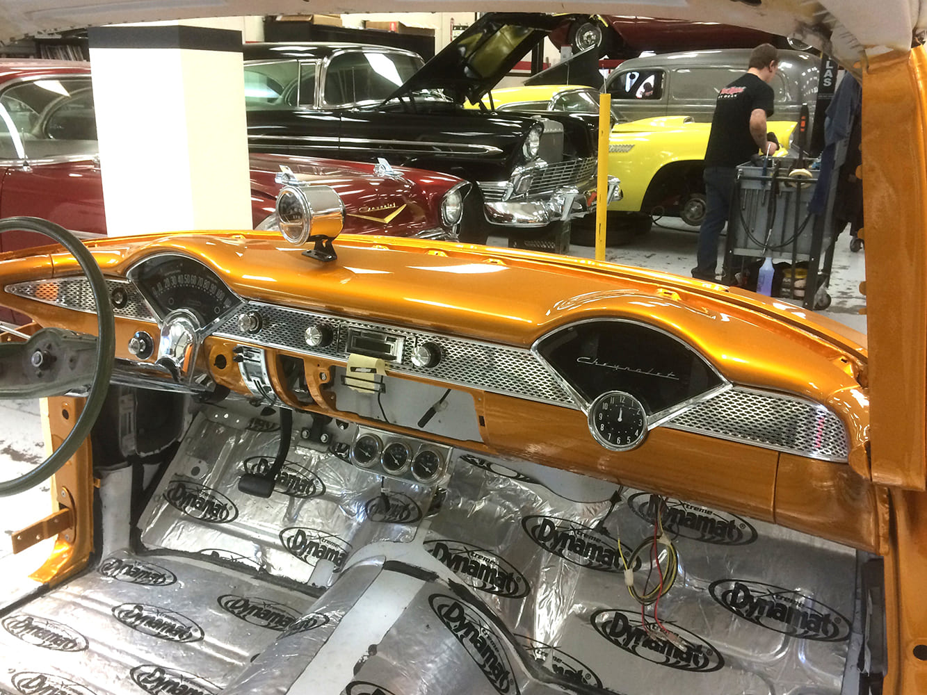 Custom painted PPG Pagan Gold dashboard with classic gauges and Dynamat sound deadening installed inside the 55 Chevy Gasser cabin.