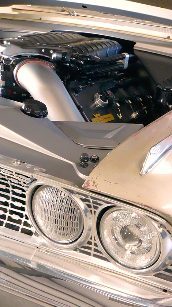 Close-up of the front fender and inner headlight housing showing the acrylic air intake ducting fresh ambient air directly into the supercharger intake tube.