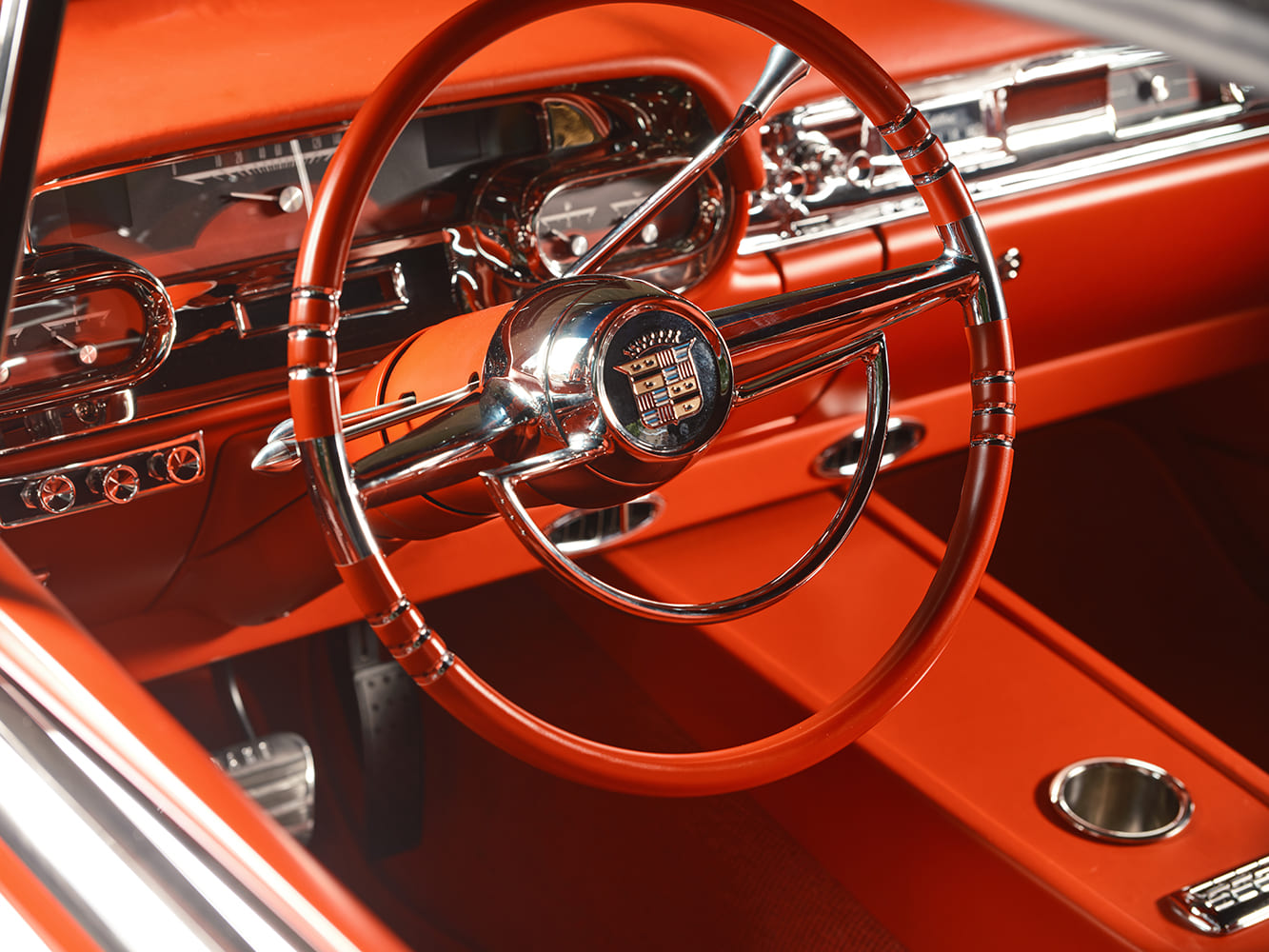 Close-up of the custom Mike Curtis steering wheel styled after the factory Cadillac piece, with tilt column and Dakota Digital gauges in the background.