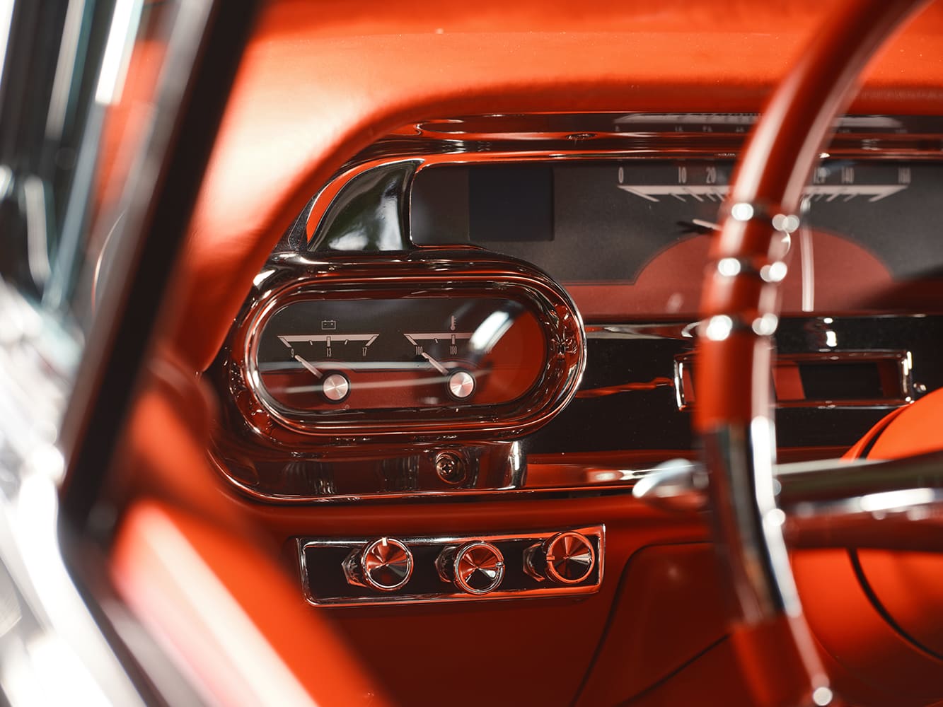 Close-up view of the chrome-bezeled Dakota Digital auxiliary gauges displaying voltage and water temperature beside headlight and dash control knobs. Image 16 (
