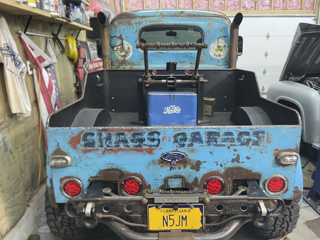 Direct rear perspective of the patina blue wrecker bed displaying painted "SKASS GARAGE" lettering, circular red LED tail lamps, vintage Pepsi cooler, and Pennsylvania license plate.