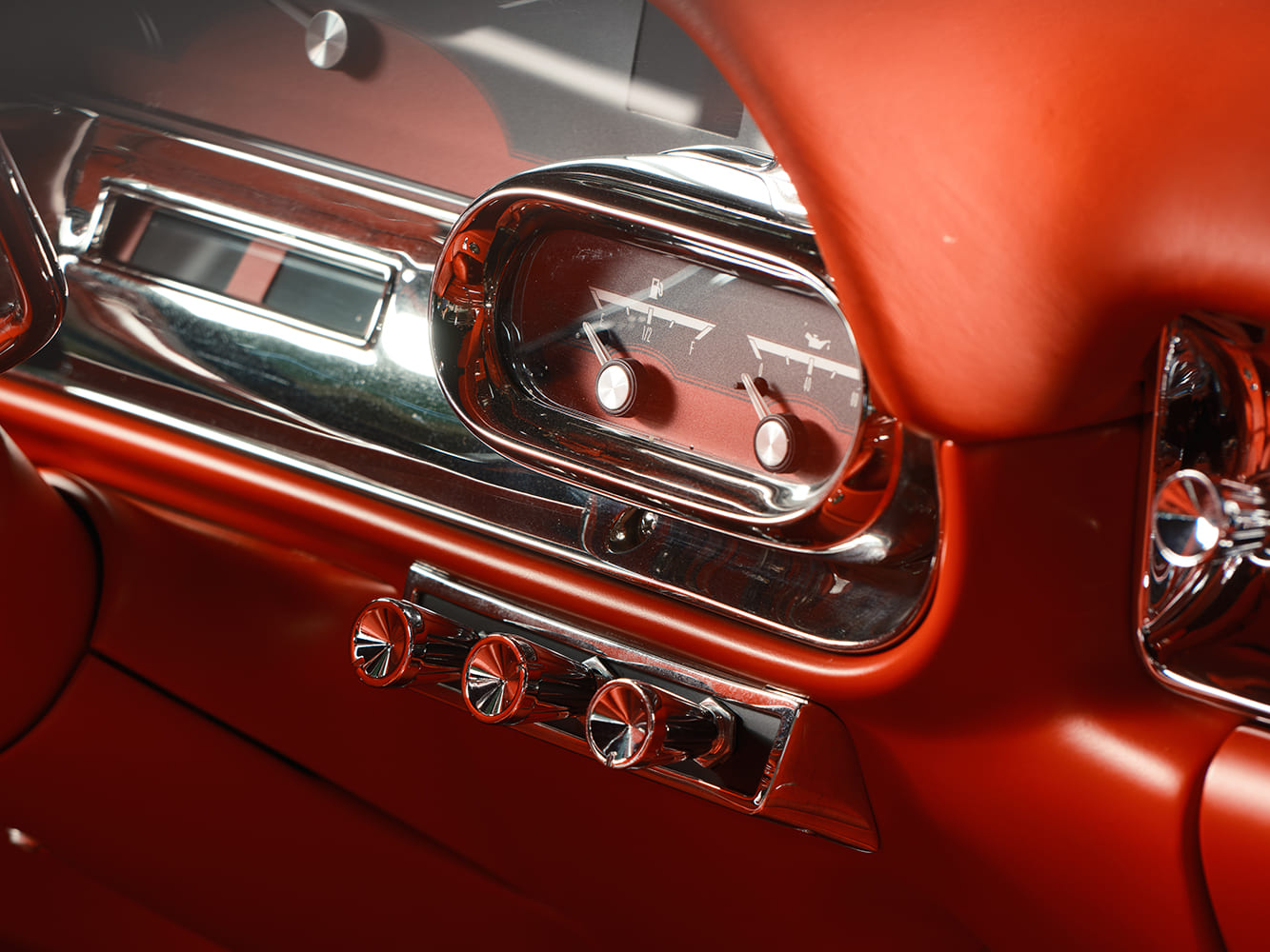 Macro view of the right-side instrument pod housing modern electronic fuel level and oil pressure analog needles inside chrome bezels.
