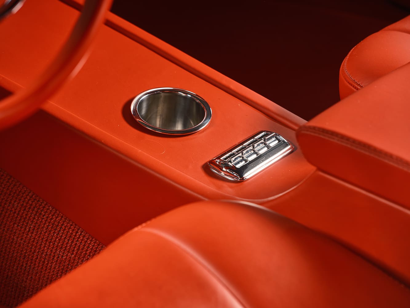 High-angle detail of the custom center console showing the polished aluminum cup holder and four-gang chrome power window switch cluster.