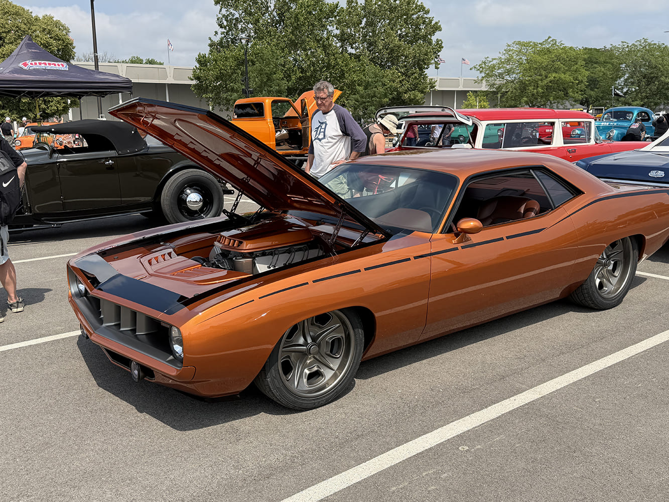Front three-quarter perspective of a metallic copper 1971 Plymouth Barracuda pro-touring muscle car with raised hood showing a custom engine enclosure.