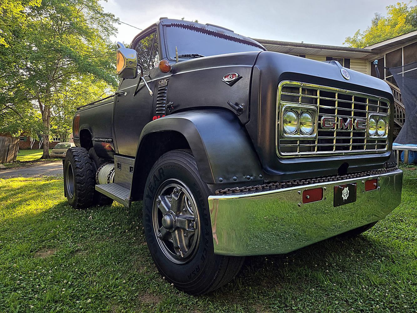 Low-angle front view showcasing the iconic chrome grille, quad headlights, and heavy-duty front bumper on a 1967 GMC 7500.