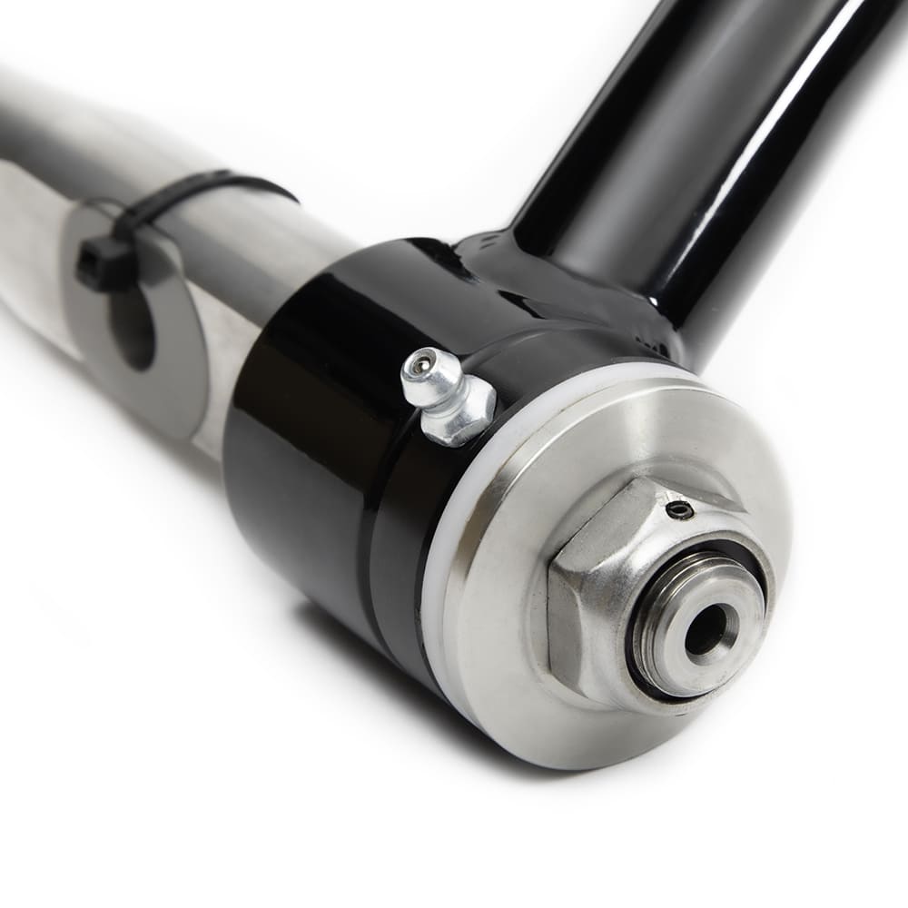 Close-up of Detroit Speed S-10 suspension tubular control arm cross-shaft bushing with integrated grease zerk.