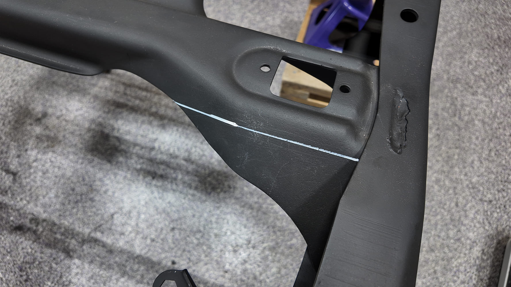 Marked cut line on Chevy S-10 chassis frame crossmember for clearance when installing Detroit Speed QuadraLink rear suspension.