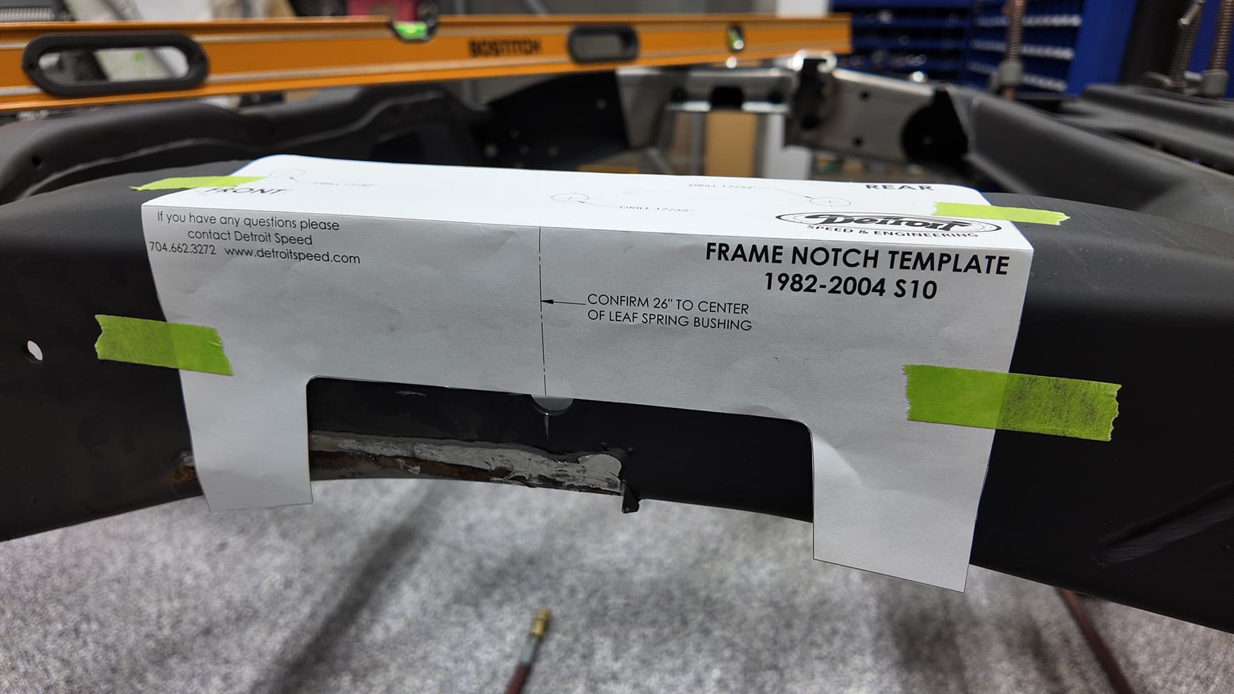 Detroit Speed frame notch paper template taped onto a 1982 to 2004 Chevy S-10 frame rail for suspension notch cutting.
