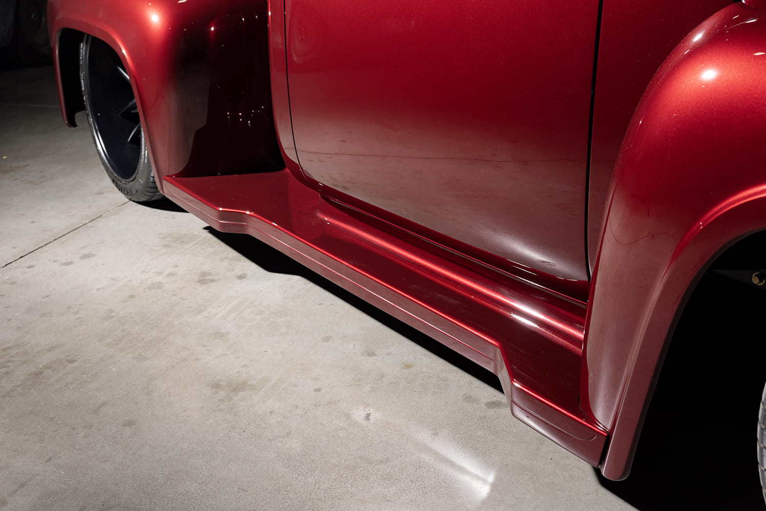 Low side angle highlighting the body-color contoured running board flowing seamlessly between the front and rear stepside fenders.