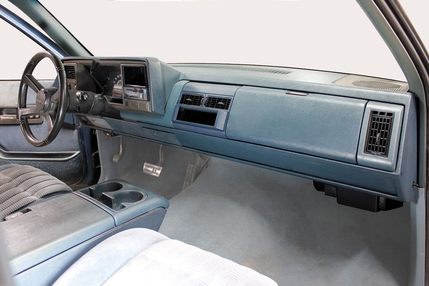 Factory blue interior and dashboard of a 1988 to 1994 GM OBS truck fitted with an Old Air Products under-dash climate-control system.