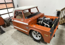 Cool Classic Trucks to See at TK Customs Front three-quarter angle of an orange Dodge D100 pickup cab undergoing a Cummins inline-six turbo diesel swap with the bed detached.